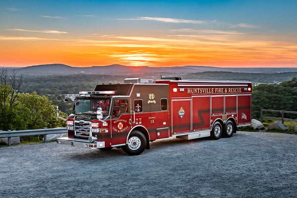 A Velocity Heavy-Duty Rescue fire truck in front of mountains, trees and a sunset.