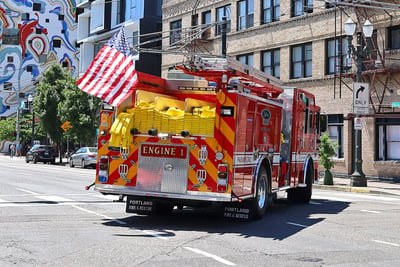 An electric fire truck turns a corner at a stop light in Portland’s downtown district.