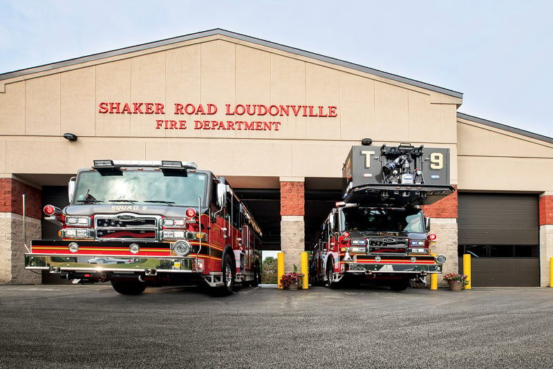 Two Pierce Manufacturing fire trucks are pulling out of station bays at Shaker Road Loudonville Fire Department.