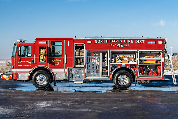 The driver's side of an Enforcer pumper with compartments open showing tools and equipment.