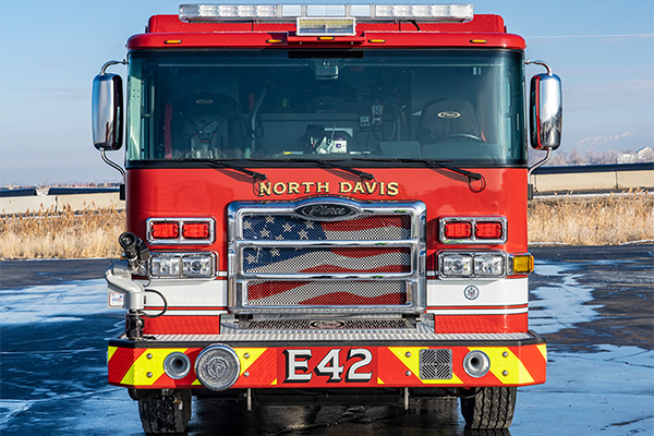 The front of an Enforcer Pumper with an American flag on the grille.