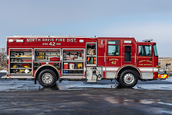 The officer's side of North Davis Fire Districts pumper with the compartments open showing tools and equipment.