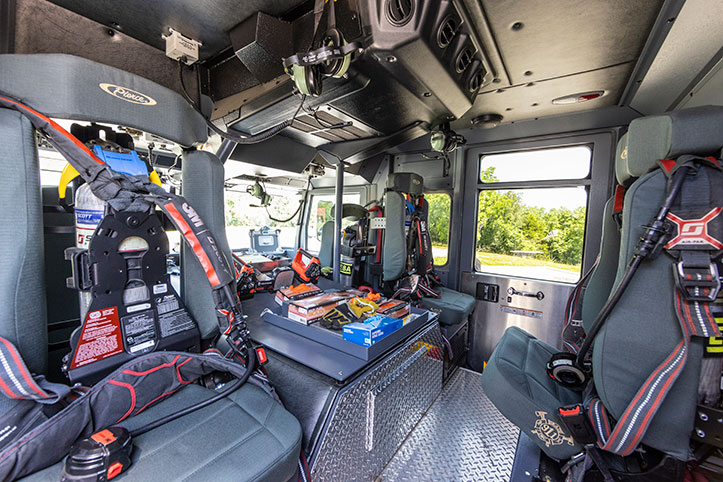 The crew cab interior of a fire truck showing seats and equipment.