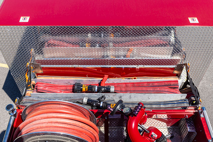 The view from on top of a fire truck showing crosslays filled with hose and a booster reel.