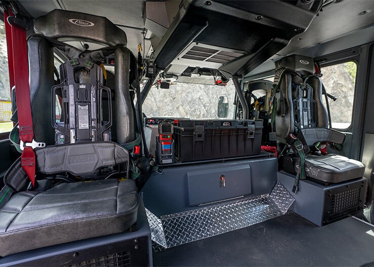 The interior crew cab of a fire truck with seating for firefighters.