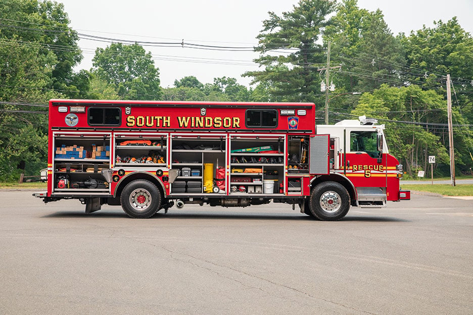 The Officer's side of a Velocity Walk-In Heavy-Duty Rescue fire truck with the compartments open showing equipment.