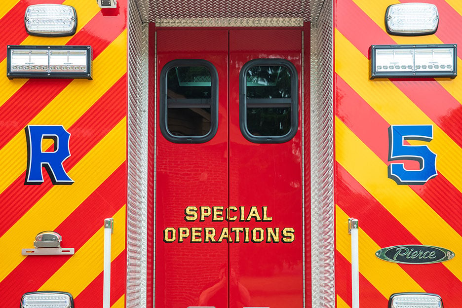 The rear entrance of a Pierce Walk-In Heavy-Duty Rescue fire truck with lights and a special operations graphic on the doors.