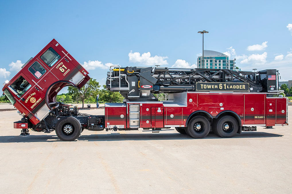 The drivers side of an Enforcer Ascendant 100 Aerial Tower with the cab tilted up in an empty parking lot on a sunny day.