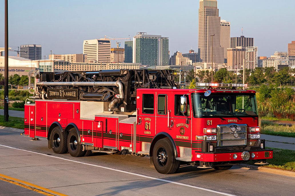 The front officers side of an Enforcer Ascendant Tower on a road in front of a city skyline.