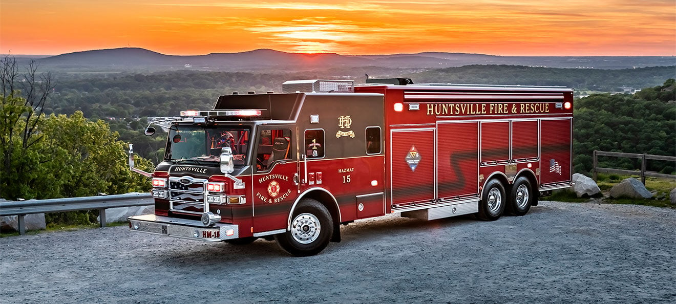 A Velocity Heavy-Duty Rescue fire truck in front of mountains, trees and a sunset.