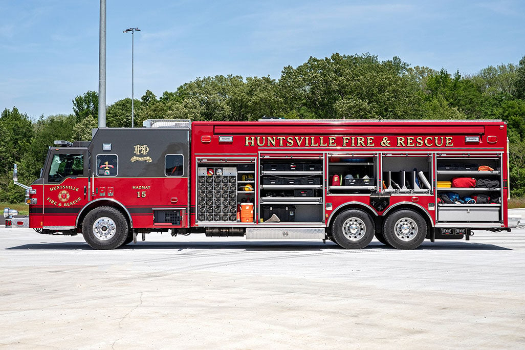 The drivers side of a combination heavy-duty rescue fire truck with the compartment doors open.